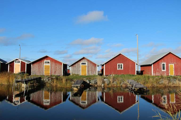 Röda båthus vid vatten