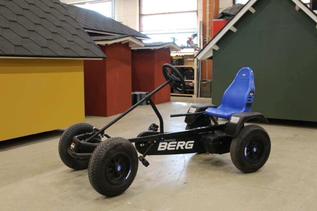 A pedal car with little houses in the background.