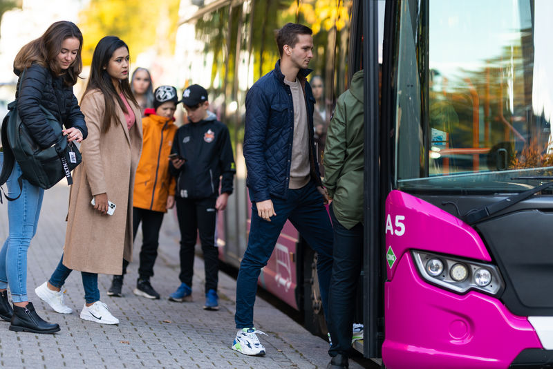 Människor som går till bussen.