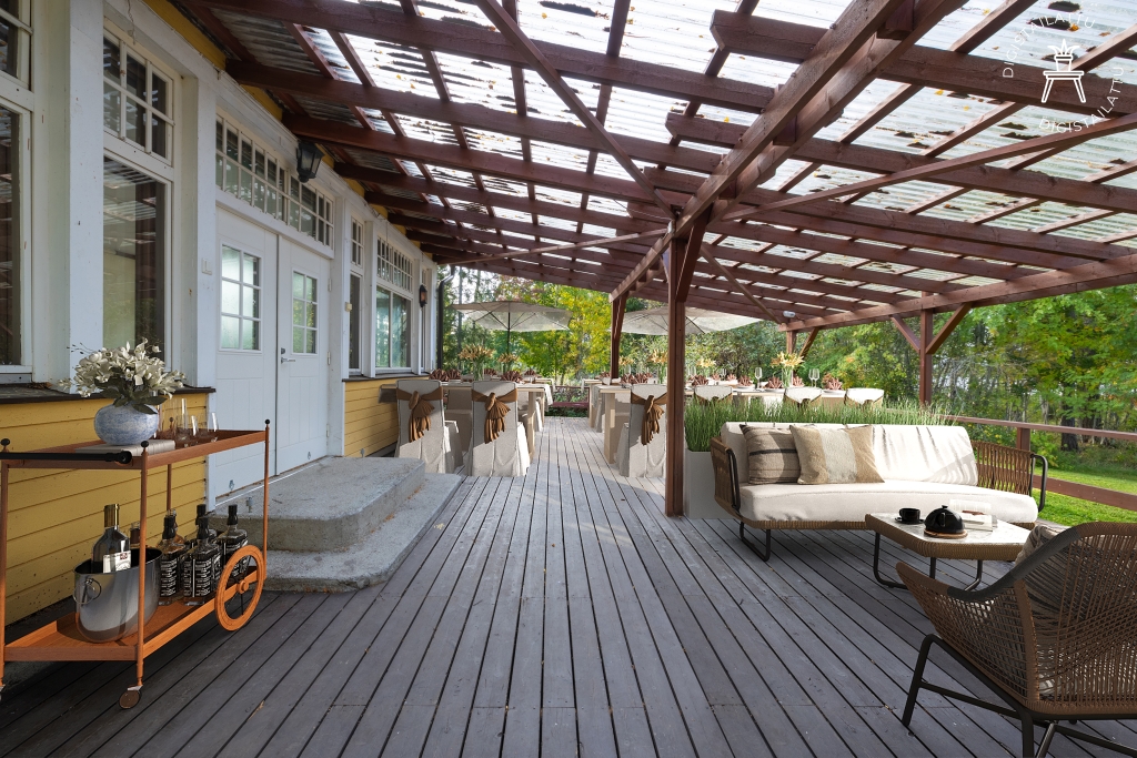 Covered and spacious terrace with a view of the lush landscape. The terrace features a cozy seating area and a dining space set for celebrations.